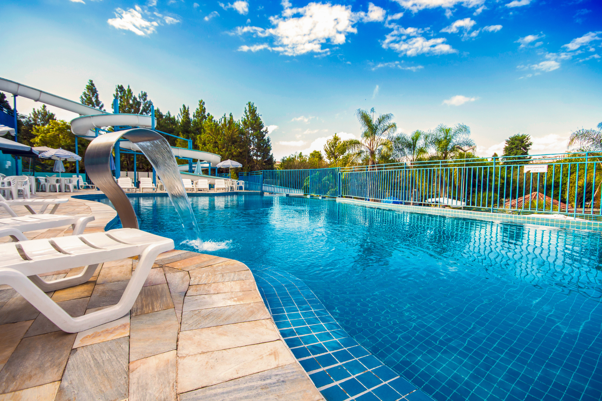 Piscina do Village Inn cercada por palmeiras