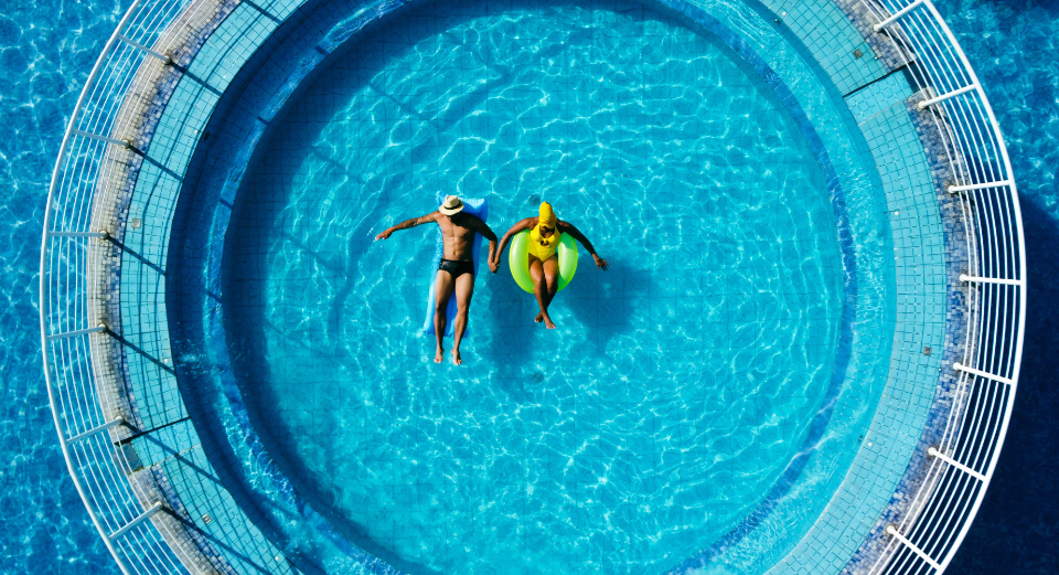 Vista de cima da piscina externa do Cassino Resort com hóspedes em boias